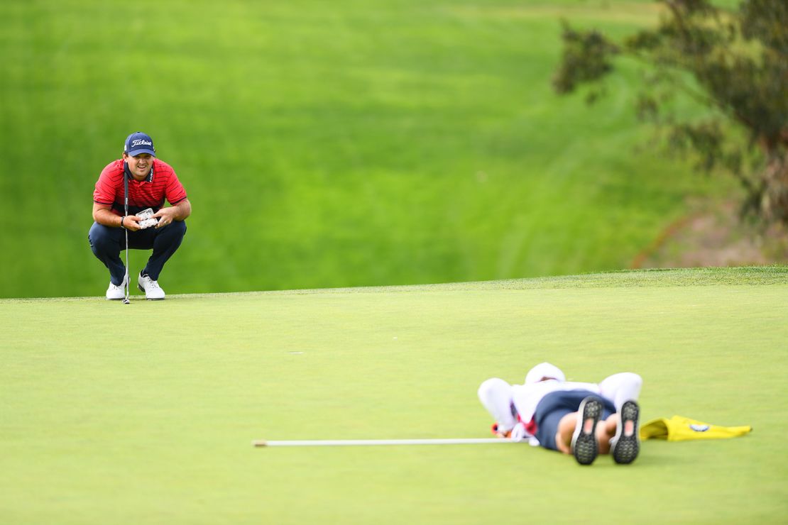 Reed and his caddie Kessler Karain line up a putt during the final round of the Farmers Insurance Open.
