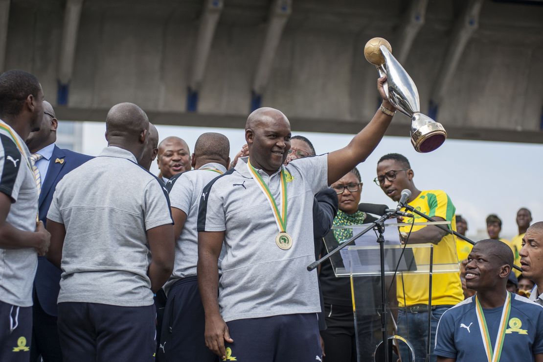 Head coach Pitso Mosimane of Mamelodi Sundowns holds the trophy as the team arrives at the Tambo Airport after they were crowned 2016 CAF Champions League champions, in Johannesburg, South Africa on October 26, 2016.