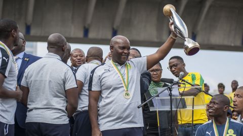 Head coach Pitso Mosimane of Mamelodi Sundowns holds the trophy as the team arrives at the Tambo Airport after they were crowned 2016 CAF Champions League champions, in Johannesburg, South Africa on October 26, 2016.