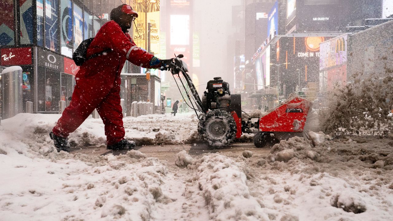 A worker clears snow off the sidewalks in Times Square, New York City, on Monday.
