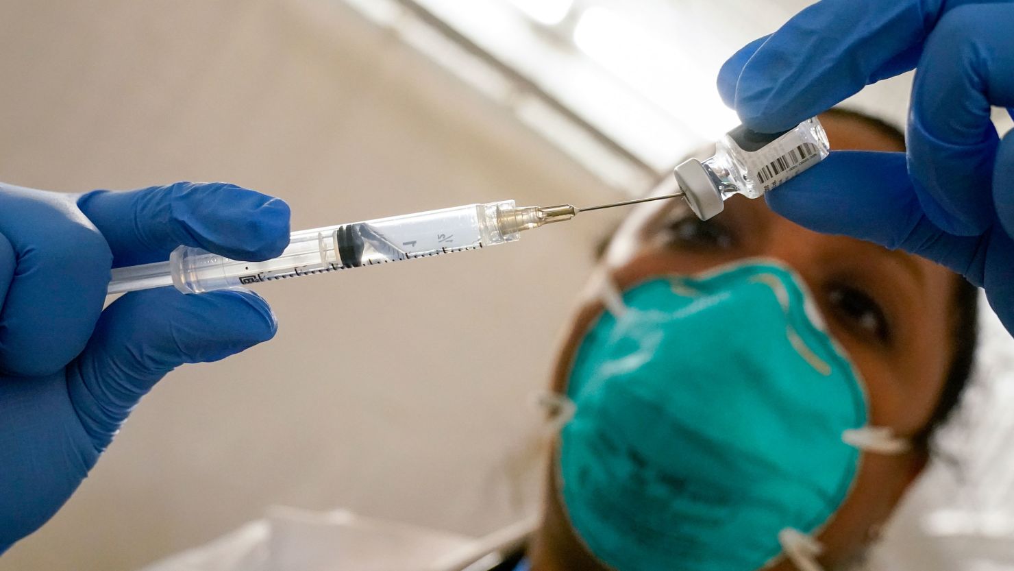 Dr. Yomaris Peña, an internal medicine physician with Somos Community Care, extracts the last bit of Pfizer/BioNTech Covid-19 vaccine from a vial so as not to waste it at a vaccination site at the Corsi Houses, on January 15 in the East Harlem neighborhood of New York.