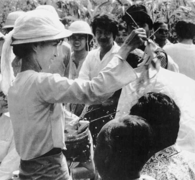 Suu Kyi sprinkles water over the heads of her followers during a traditional new year ceremony in Yangon in 1989. Five days of celebrations were marked by anti-government protests closely watched by armed troops.