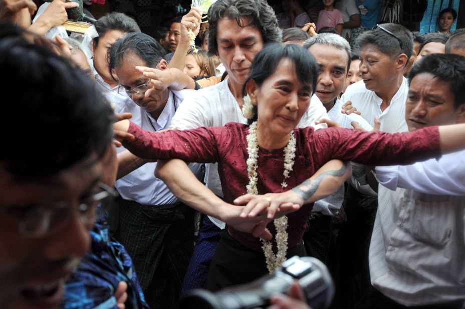 Suu Kyi is held by her son Kim Aris as she is greeted by supporters during a visit to the ancient temple city of Bagan in 2011.