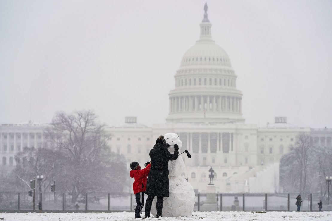 Janine Iselmann and her son Max, build a snowman in Washington, DC, on Monday.