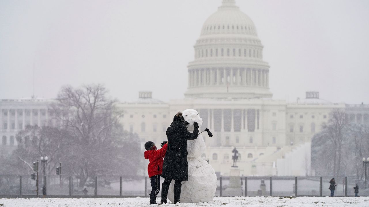 Janine Iselmann and her son Max, build a snowman in Washington, DC, on Monday.