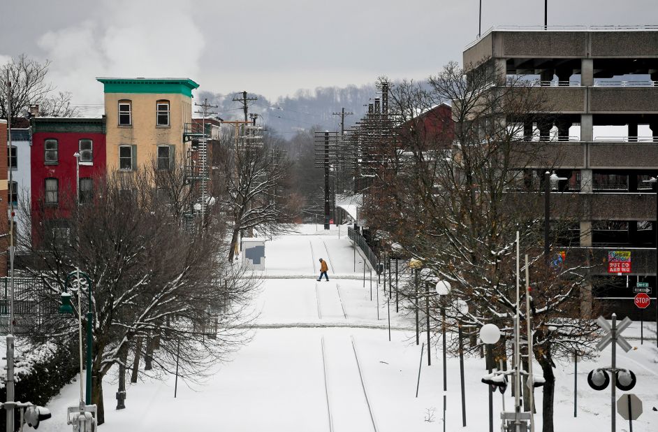 A person crosses snowy railroad tracks in Reading, Pennsylvania, on Monday.