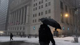 A man walks past the New York Stock Exchange during a snowstorm, Monday, Feb. 1, 2021, in New York. (AP Photo/Mark Lennihan)