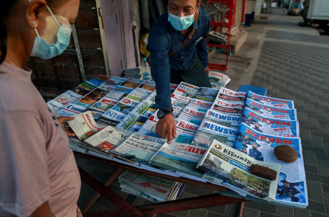 A newspaper seller points at a front-page of a newspaper in Yangon, Myanmar, Febuary 2, 2021. 
