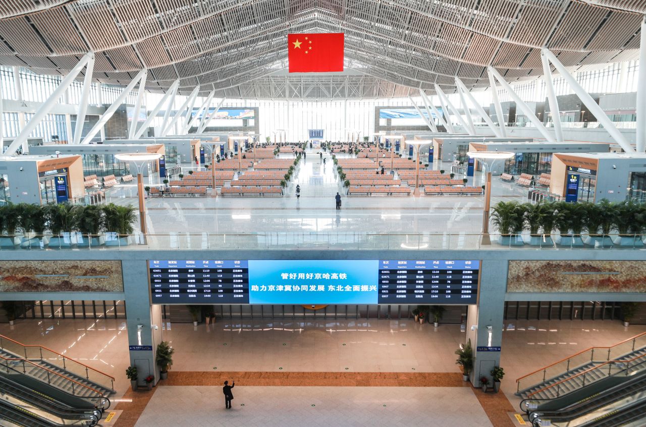 A Chinese flag hangs over an empty departure hall at Beijing Chaoyang Railway Station on the first day of the Spring Festival travel rush on January 28, 2021.