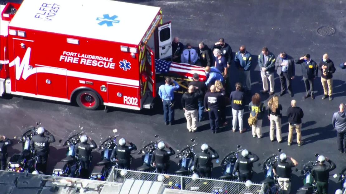 A body draped in an American flag is transported from an ambulance following the fatal shooting of two FBI agents in Sunrise, Florida, on Tuesday. 