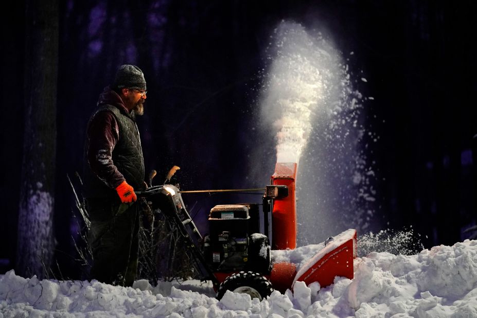 Rick Wallace clears a sidewalk with a snowblower in Freeport, Maine.