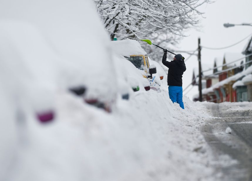 A man clears snow off his car in West Reading, Pennsylvania, on Tuesday, February 2.
