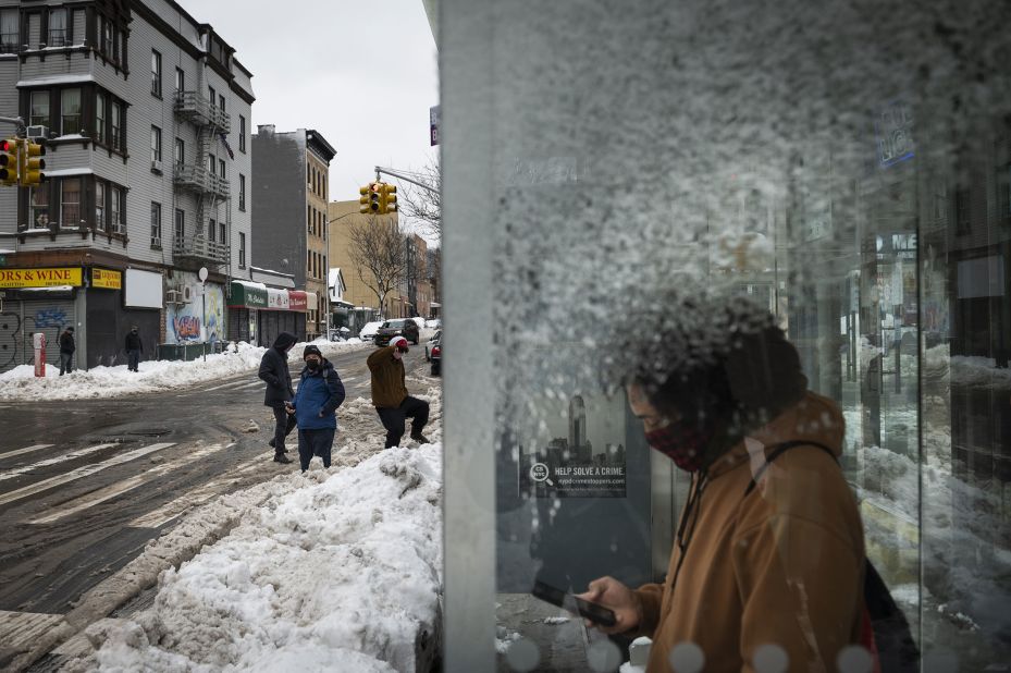 A commuter waits at a bus stop in Brooklyn, New York, on Tuesday.