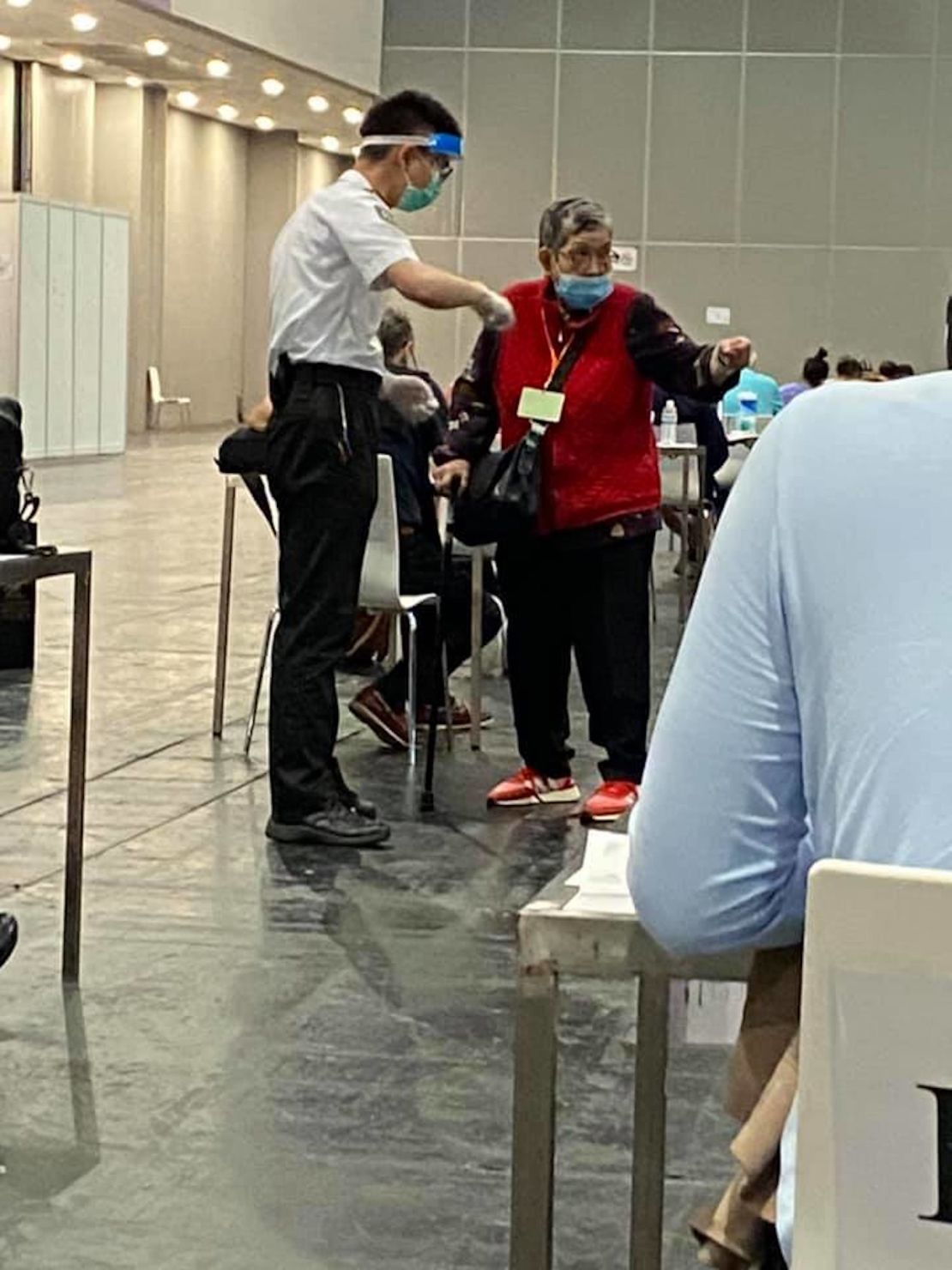 Anna Gong is seen waiting at the quarantine center in this photograph from Sharon Hawkins Leung, one of the group members who updated Jameson Gong on his mother's status. Leung joked her Cantonese isn't very good but it sounded like Anna Gong was giving the guard a piece of her mind.