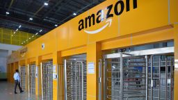In this photo taken on September 18, 2018 an employee of Amazon India walks towards a security gate at Amazon's newly launched fulfilment centre situated on the outskirts of Bangalore. - The US-headquartered online retail giant Amazon opened its latest fulfilment centre in Karnataka as part of its long-term, multi-billion-dollar bid to expand its footprint in India's growing e-commerce industry. (Photo by MANJUNATH KIRAN / AFP)        (Photo credit should read MANJUNATH KIRAN/AFP via Getty Images)