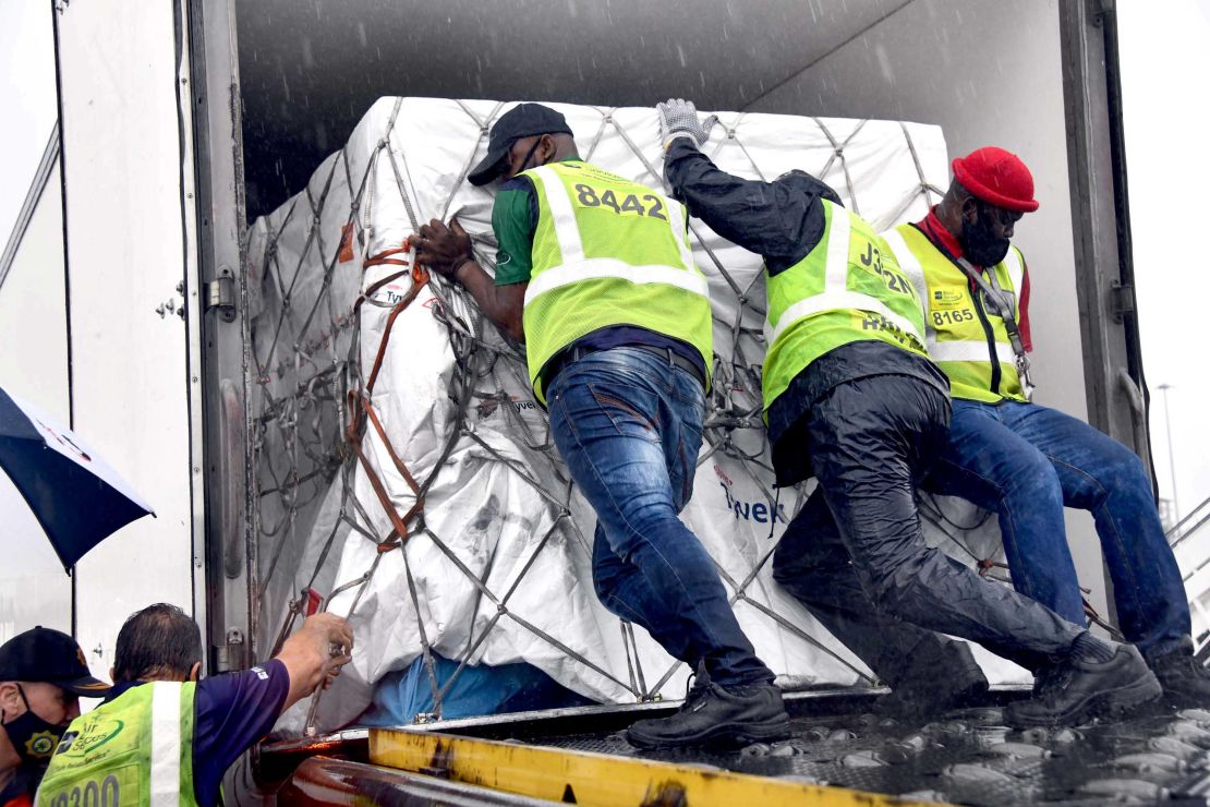 Workers load South Africa's first coronavirus vaccine doses as they arrive at an airport in Johannesburg, South Africa, in this handout picture taken February 1, 2021.