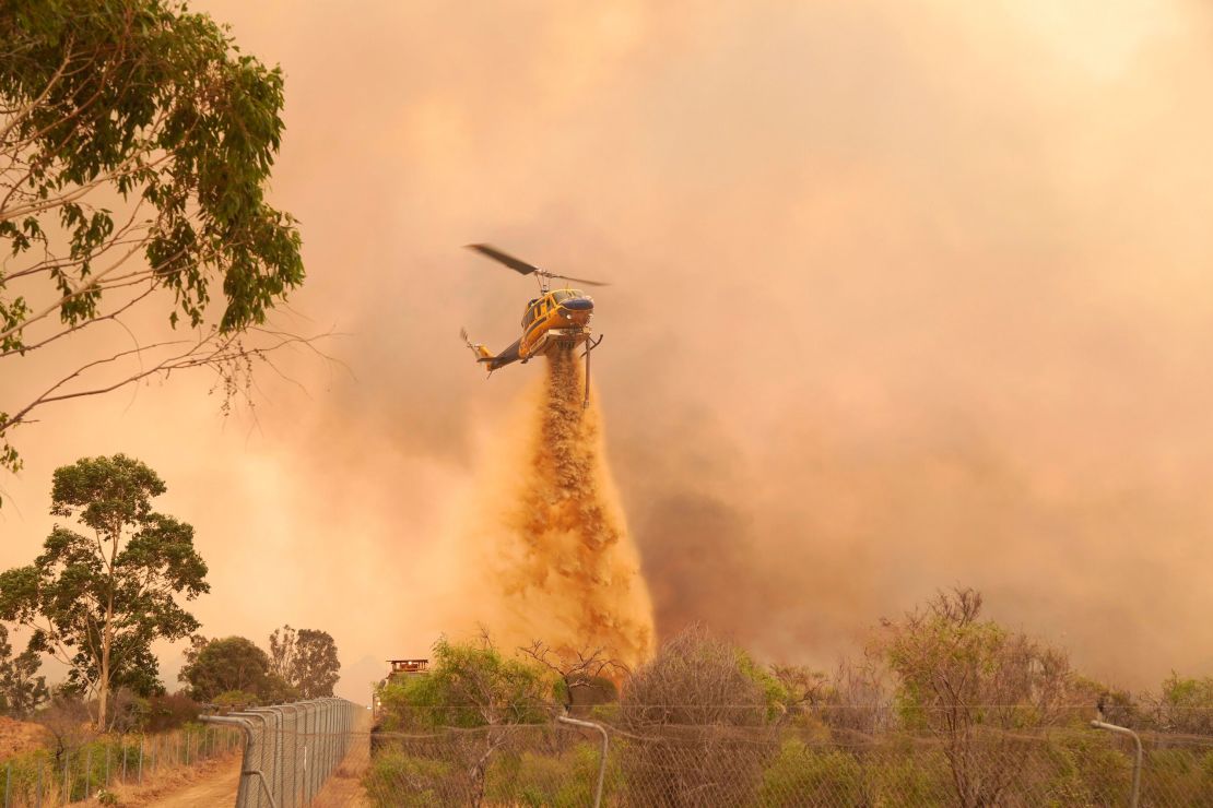 A helicopter drops fire retardant on a fire near Wooroloo, northeast of Perth, Australia, on February 2, 2021. 