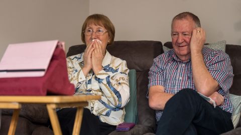 Trish Skinner sits with her husband Peter at home in Northamptonshire as they watch her father's burial service over Zoom. 