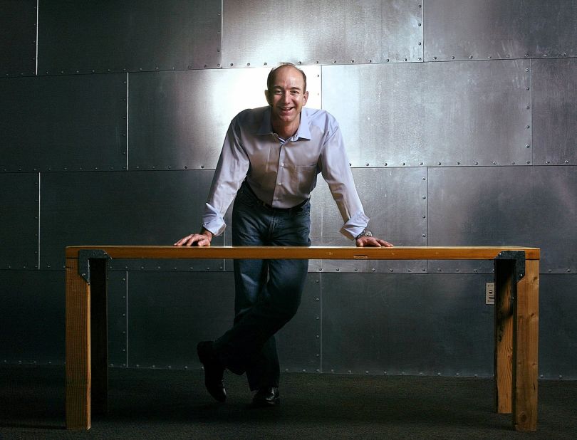 Jeff Bezos stands with one of Amazon's trademark door-desks at the company's Seattle headquarters in 2004.