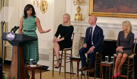 Bezos listens to first lady Michelle Obama at a White House event in 2016. The event announced commitments from more than 50 companies to hire and train veterans and military spouses. Bezos announced a commitment by Amazon to hire 25,000 more military veterans in the next five years.