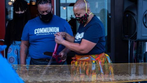 Damon Bomar (left) with his mother, Chef Kristi Brown, cut the ribbon to officially open their new Seattle restaurant, Communion, on December 5, 2020.