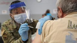 Sergeant Jurne Smith-Traylor (L) of the Illinois Air National Guard administers a Pfizer Covid-19 vaccine to Arthur Barsotti at a vaccination center established at the Triton College in River Grove, Illinois, on February 3, 2021. - The site is the second large-scale vaccination center in Cook County, which includes the city of Chicago. More than 4,000 vaccines are expected to be given at that location on a weekly basis. (Photo by KAMIL KRZACZYNSKI / AFP) (Photo by KAMIL KRZACZYNSKI/AFP via Getty Images)