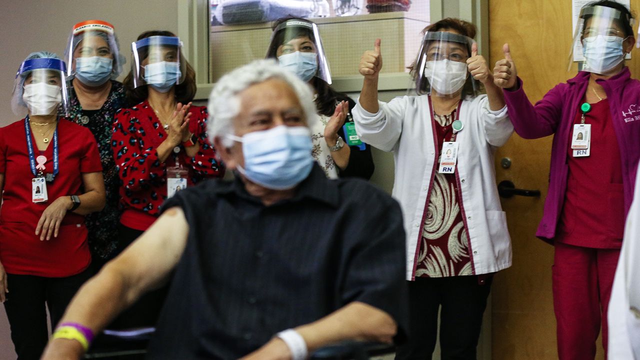 CHULA VISTA, CALIFORNIA - DECEMBER 21:  Sharp HealthCare caregivers celebrate after long-term care patient Carlos Alegre received the Pfizer-BioNTech COVID-19 vaccine at Birch Patrick Skilled Nursing Facility at Sharp Chula Vista Medical Center on December 21, 2020 in Chula Vista, California. 72-year-old Alegre is the first patient to receive the vaccine in San Diego County. Long-term care patients and frontline healthcare workers are among those in the CDC's highest priority group for vaccination.  (Photo by Mario Tama/Getty Images)