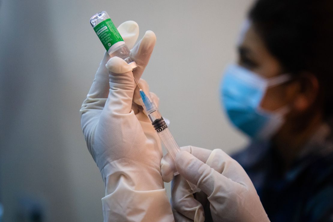 A health worker in Nepal holds up a vial of the AstraZeneca-Oxford coronavirus vaccine to administer to frontline health workers at the Armed Police Force Hospital.