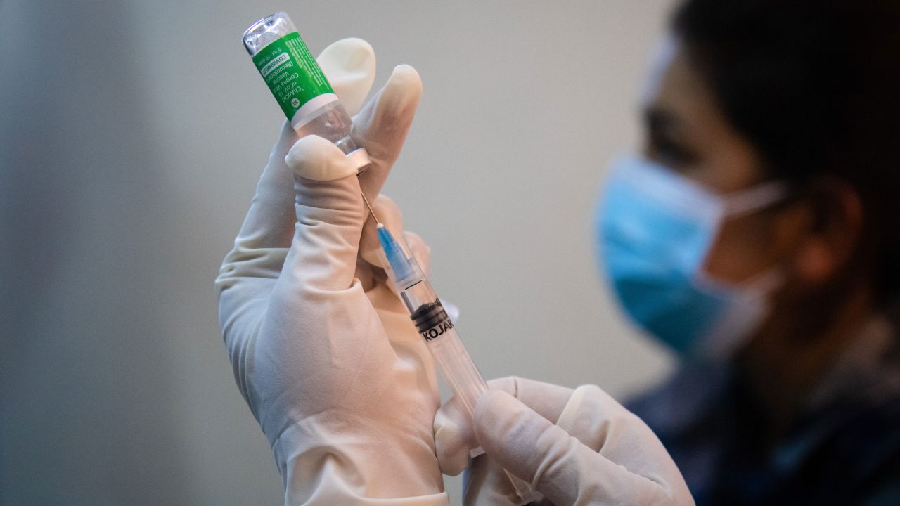 A health worker in Nepal holds up a vial of the AstraZeneca-Oxford coronavirus vaccine to administer to frontline health workers at the Armed Police Force Hospital.