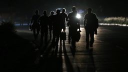 The silhouette of Honduran migrants as they walk at 4:30 a.m. towards the Guatemalan border on January 15, 2021 in San Pedro Sula, Honduras. The caravan plans to walk across Guatemala and Mexico to eventually reach the United States. Central Americans expect to receive asylum and most Hondurans decided to migrate after being hit by recent hurricanes Eta and Iota. 