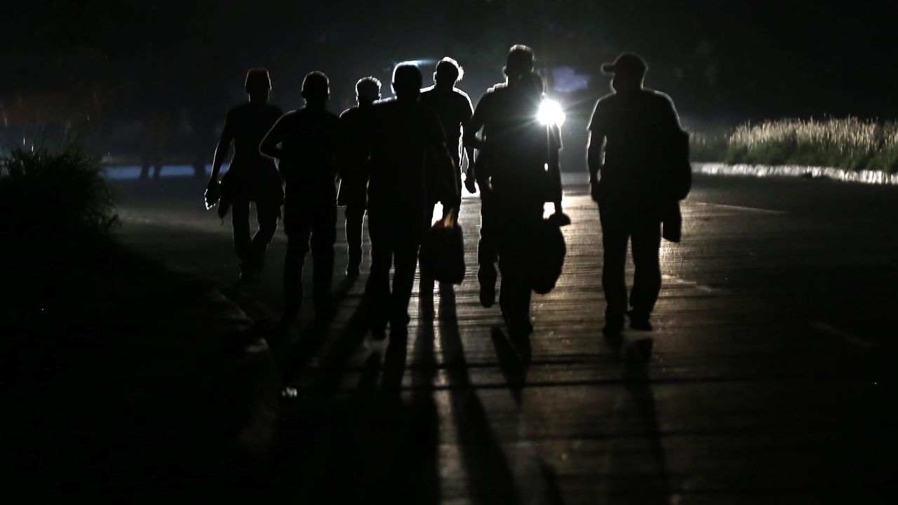 The silhouette of Honduran migrants as they walk at 4:30 a.m. towards the Guatemalan border on January 15, 2021 in San Pedro Sula, Honduras. The caravan plans to walk across Guatemala and Mexico to eventually reach the United States. 