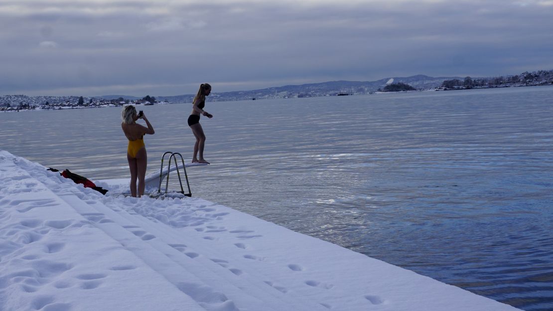 A youth prepares to jump into cold water at the Oslo harbor.