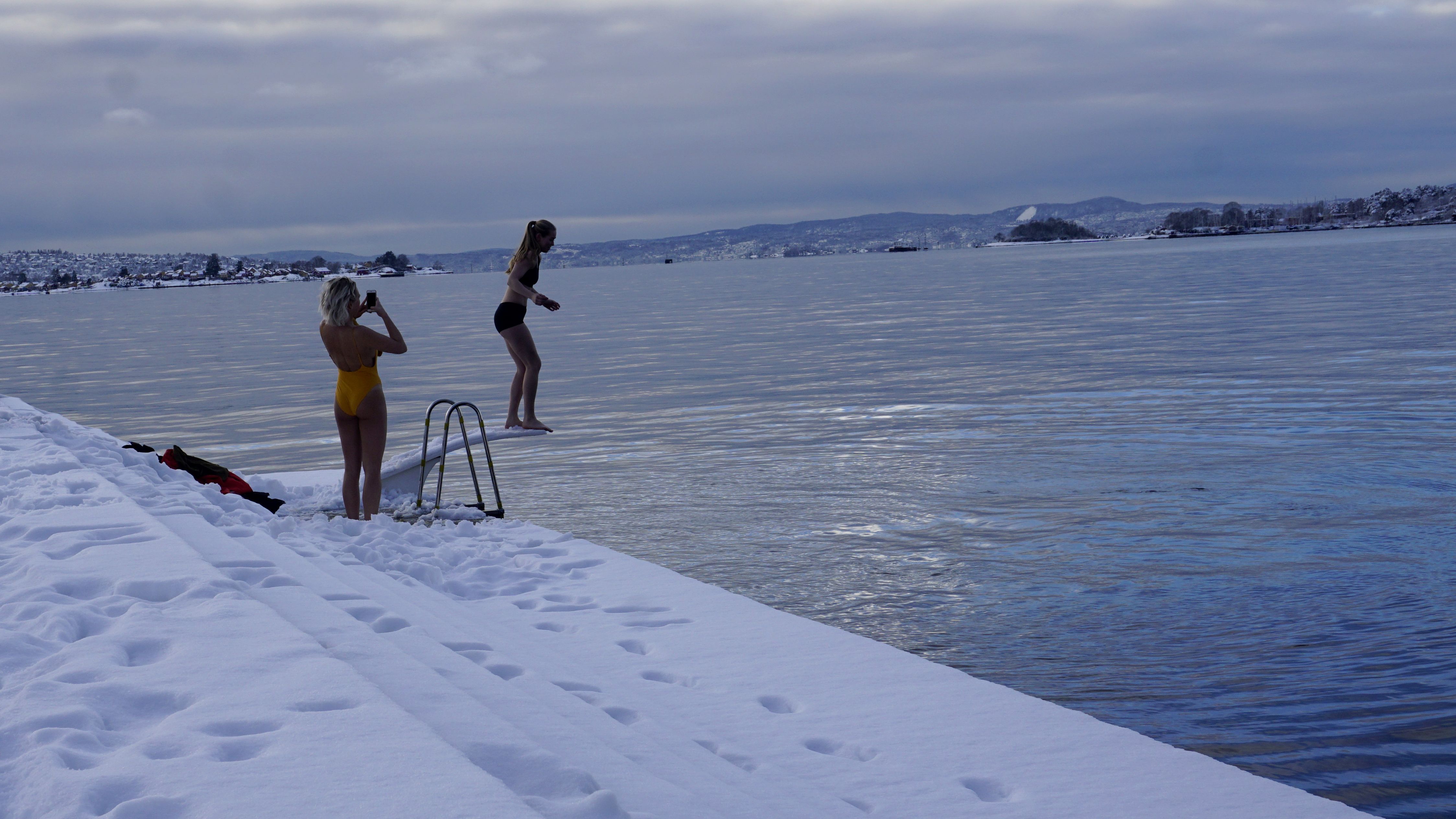 A youth prepares to jump into cold water at the Oslo harbor.