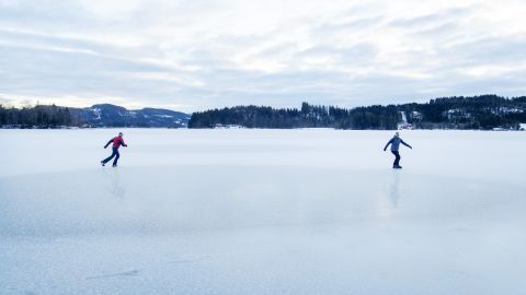 Two men skate on an icy lake in Trondheim, Norway.