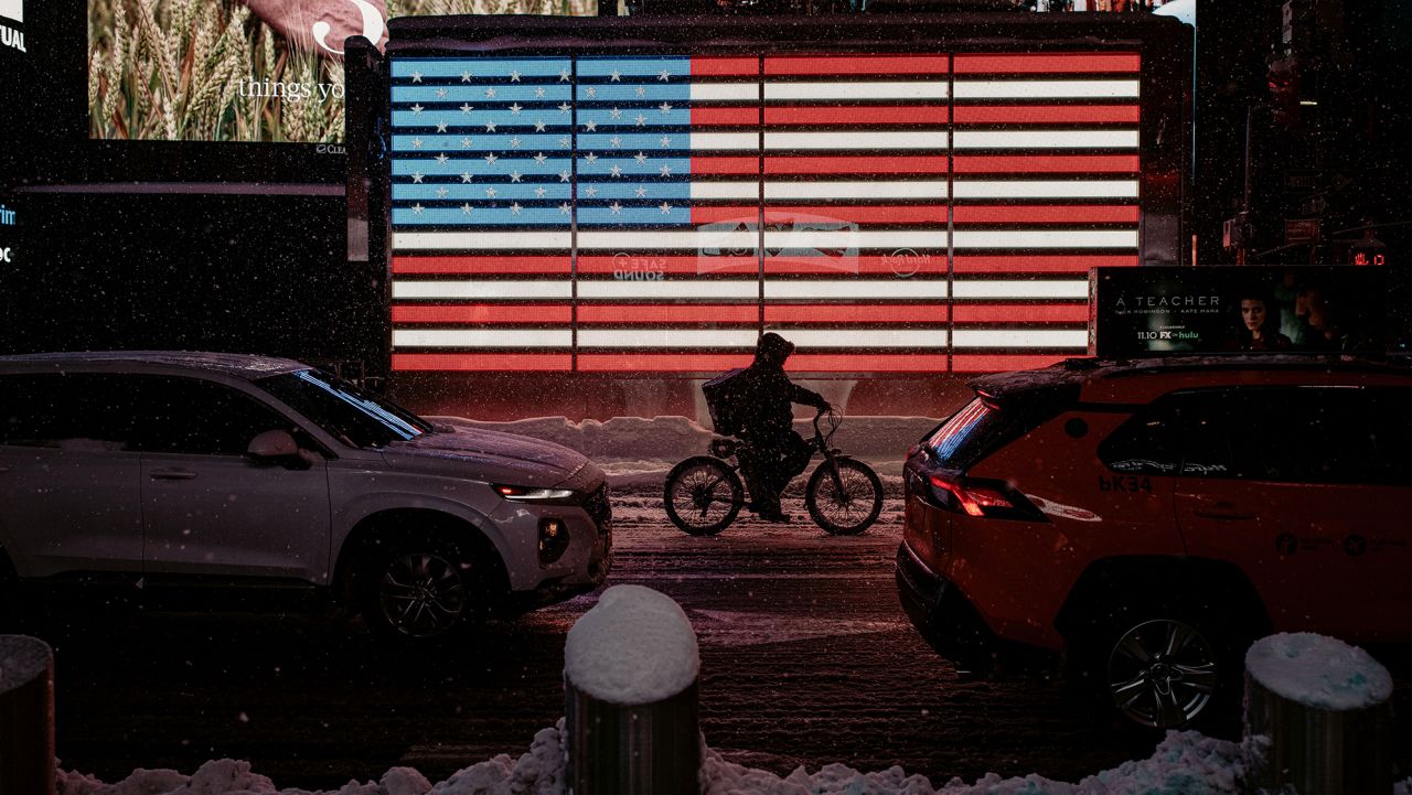 A delivery worker rides along a street as snow continues to fall in Times Square on February 01, 2021 in New York City. NYC Mayor Bill de Blasio declared a State of Emergency as a Nor'Easter is expected to bring blizzard-like conditions with up to 18 inches of snow into the city. (Photo by Scott Heins/Getty Images)