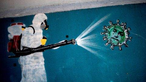 TOPSHOT - View of a mural depicting a man in protective suit spraying disinfectant on a coronavirus with Brazilian President Jair Bolsonaro's face, at the Tijuca neighborhood in Rio de Janeiro, Brazil on July 8, 2020, amid the new coronavirus pandemic. - Brazilian President Jair Bolsonaro has tested positive for the coronavirus after months of downplaying the dangers of the disease. (Photo by Mauro Pimentel / AFP) (Photo by MAURO PIMENTEL/AFP via Getty Images)