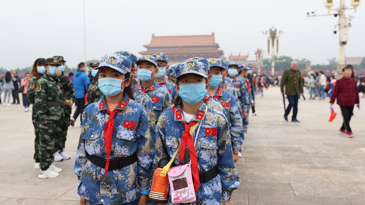 Chinese Young Pioneers wearing face masks take part in a flag-raising ceremony at Tiananmen Square on October 1, 2020 in Beijing, China.