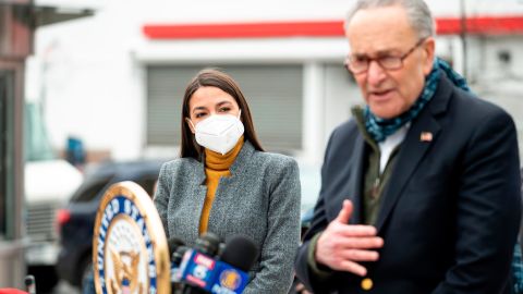 Schumer speaks as Democratic Congresswoman from New York Alexandria Ocasio-Cortez wearing a face mask to protect herself from the coronavirus, listens during a press conference in the Corona neighbourhood of Queens on April 14, 2020 in New York City. 