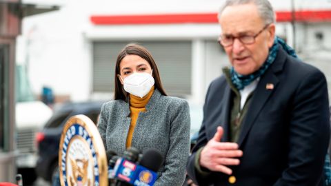 Schumer speaks as Democratic Congresswoman from New York Alexandria Ocasio-Cortez wearing a face mask to protect herself from the coronavirus, listens during a press conference in the Corona neighbourhood of Queens on April 14, 2020 in New York City.