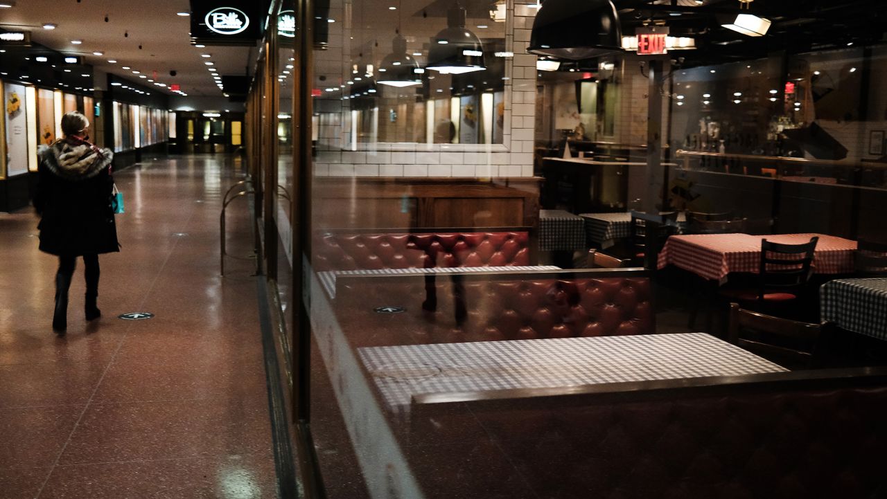 People walk by a closed restaurant in Rockefeller Center on the last Sunday before Christmas on December 20, 2020 in New York City. Rockefeller Center, where the annual Christmas tree is displayed among other holiday attractions, has far less crowds this year and numerous restrictions due to the ongoing COVID-19 pandemic. New York City has seen a slow uptick in COVID hospitalizations over the last few weeks but is still far below the numbers witnessed in the spring. (Photo by Spencer Platt/Getty Images)