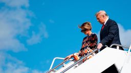 Outgoing US President Donald Trump and US First Lady Melania Trump step off Air Force One as they arrive at Palm Beach International Airport in West Palm Beach, Florida, on January 20, 2021. - President Trump and the First Lady travel to their Mar-a-Lago golf club residence in Palm Beach, Florida.