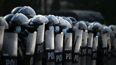 Riot police block the street as protesters hold a demonstration against the military coup in Yangon on February 7, 2021.