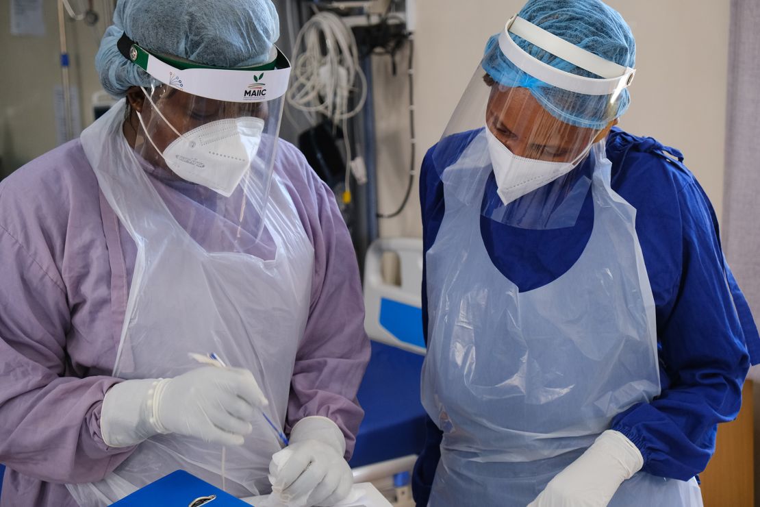 Dr. Phiri (right) talks to a nurse in a coronavirus ward.