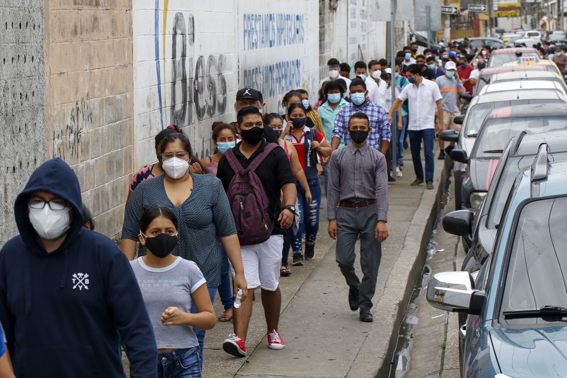 Voters line up outside a polling station during presidential and legislative elections in Guayaquil, Ecuador, Sunday, Feb. 7, 2021.