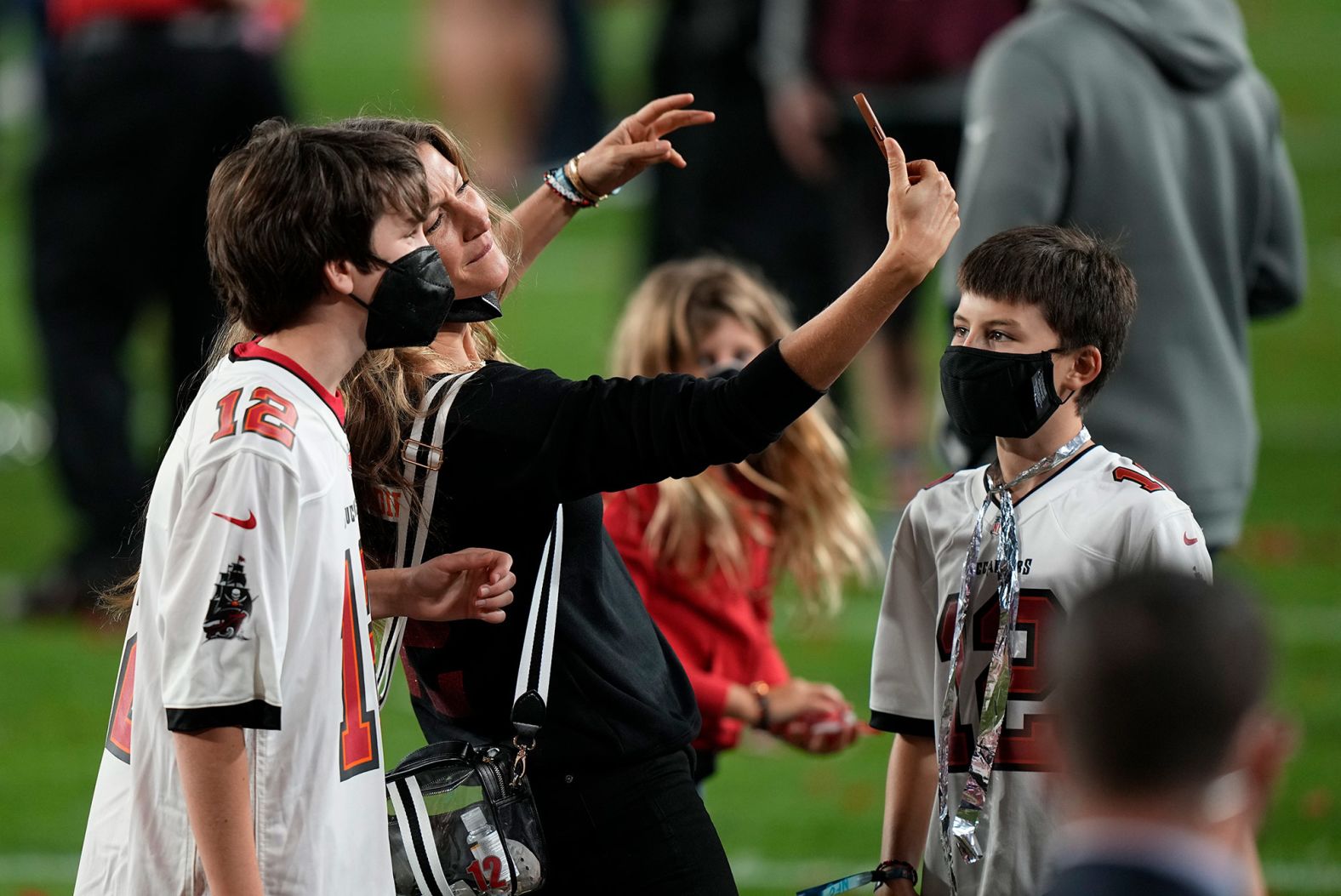 Brady's children are seen on the field as his wife, supermodel Gisele Bundchen, takes a selfie during the postgame celebrations.