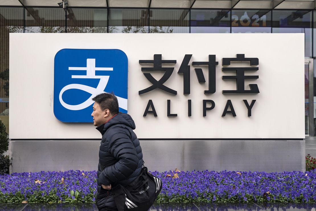 A pedestrian walks past an Alipay sign outside an Ant Group Co. office building in Shanghai, China, on Thursday, Dec. 24, 2020. 