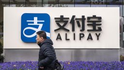 A pedestrian walks past an Alipay sign outside an Ant Group Co. office building in Shanghai, China, on Thursday, Dec. 24, 2020. 