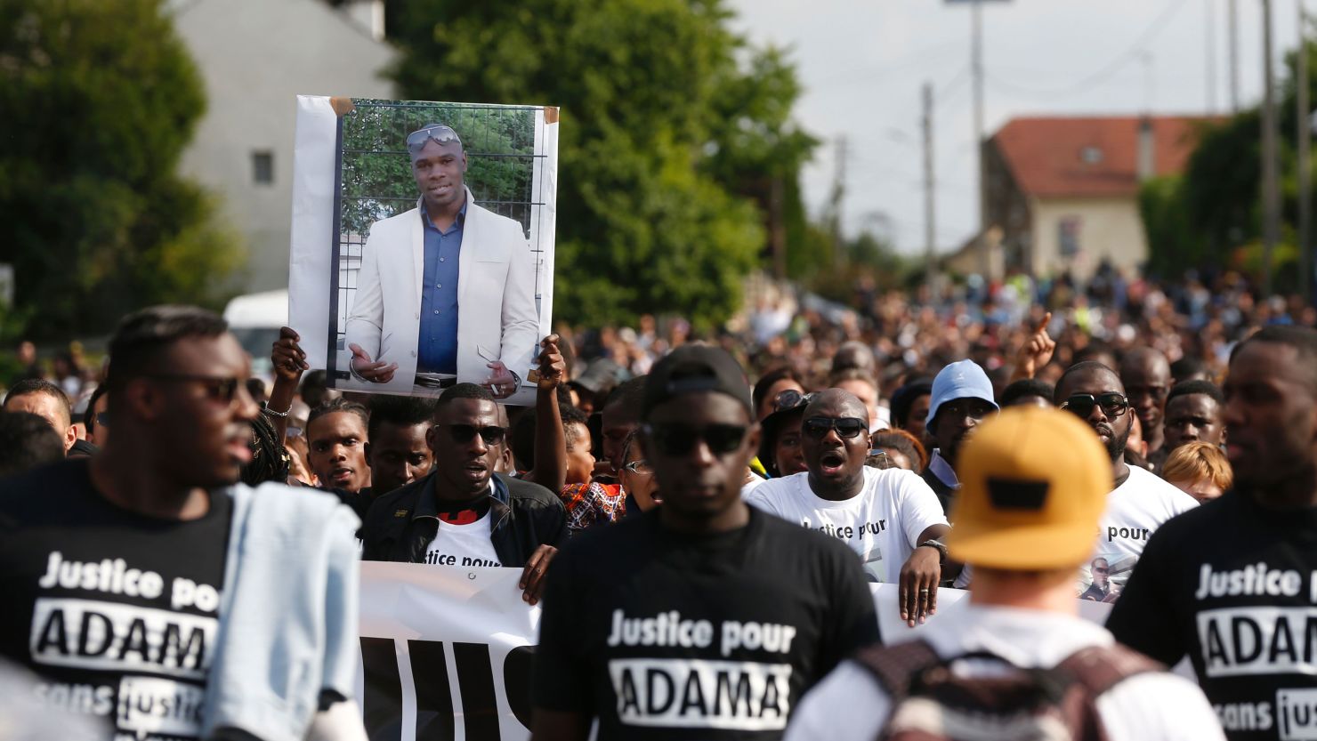 People hold a portrait picture of Adama Traore and wear T-shirts reading "Justice for Adama" on July 22, 2016.