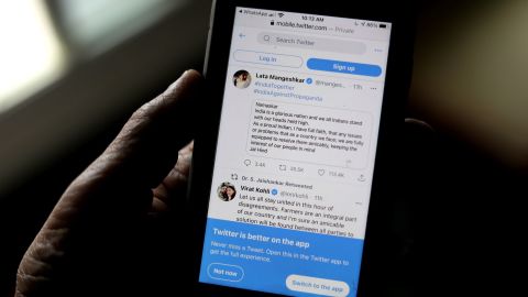 A man reads tweets by Indian celebrities, one of the many backing the Indian government, on his mobile in New Delhi, India, on Thursday.