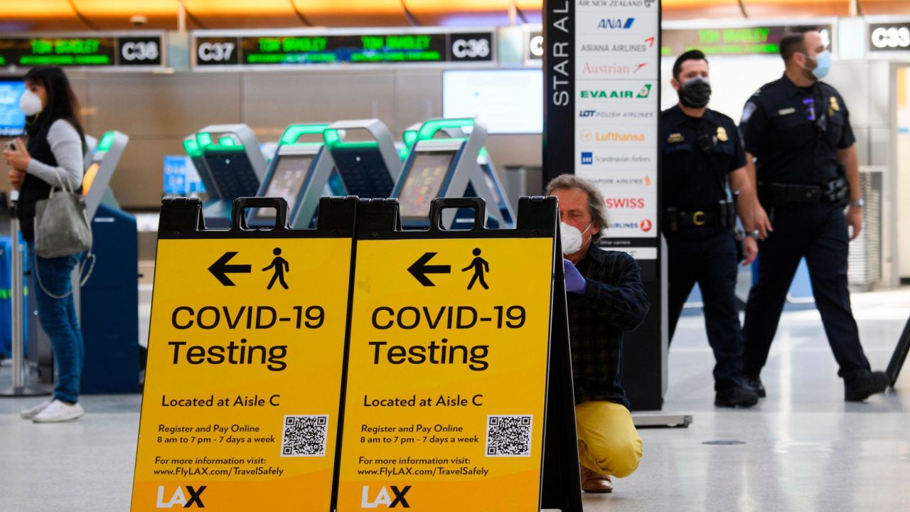 A traveler takes a photo of a Covid-19 testing sign at the Tom Bradley International Terminal (TBIT) amidst travel restrictions during the Covid-19 pandemic at Los Angeles International Airport (LAX) on February 4, 2021 in Los Angeles, California. (Photo by Patrick T. FALLON / AFP) (Photo by PATRICK T. FALLON/AFP via Getty Images)